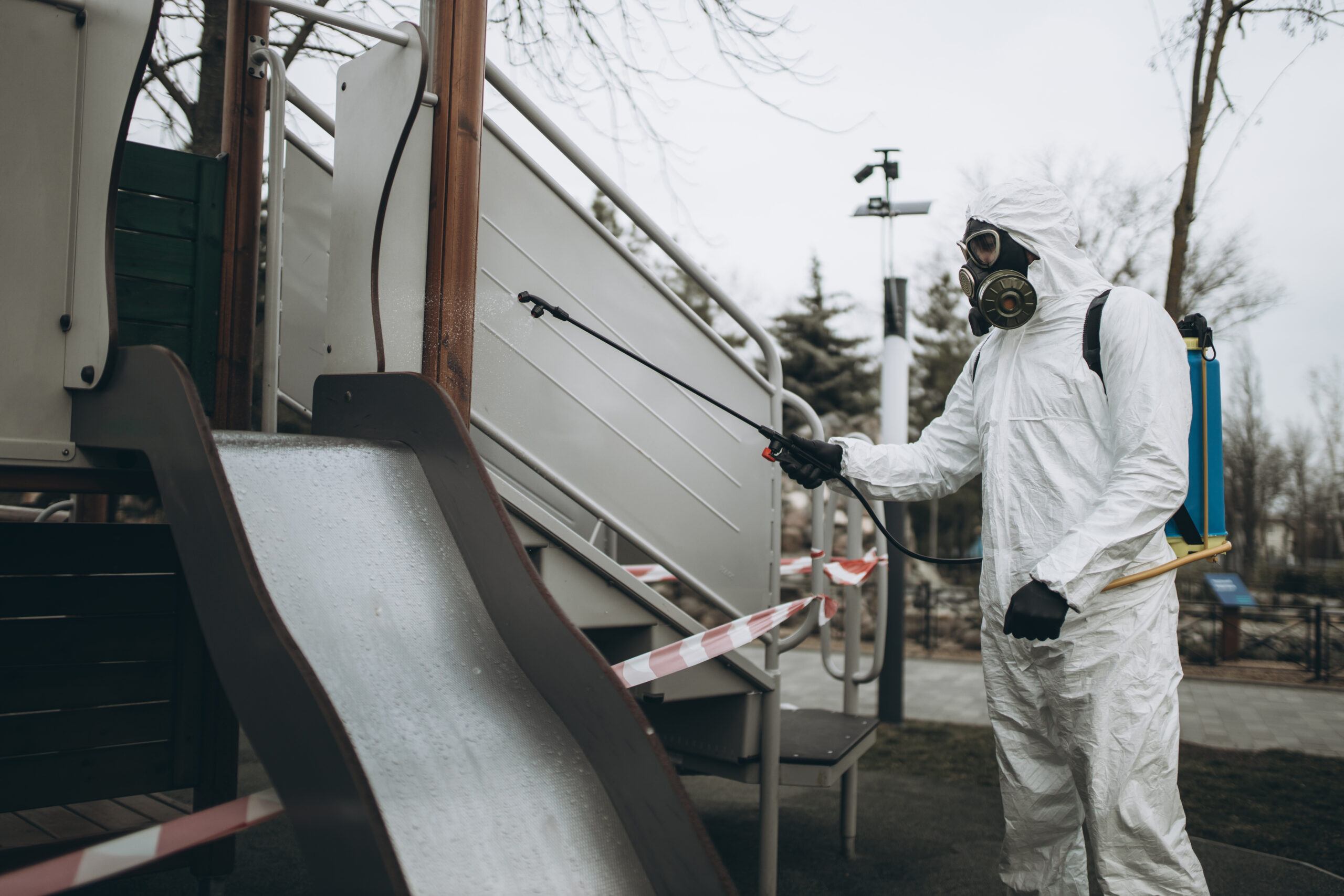Cleaning and Disinfection on the playground in the sity complex amid the coronavirus epidemic Professional teams for disinfection efforts Infection prevention and control of epidemic Protective suit and mask and spray bag,